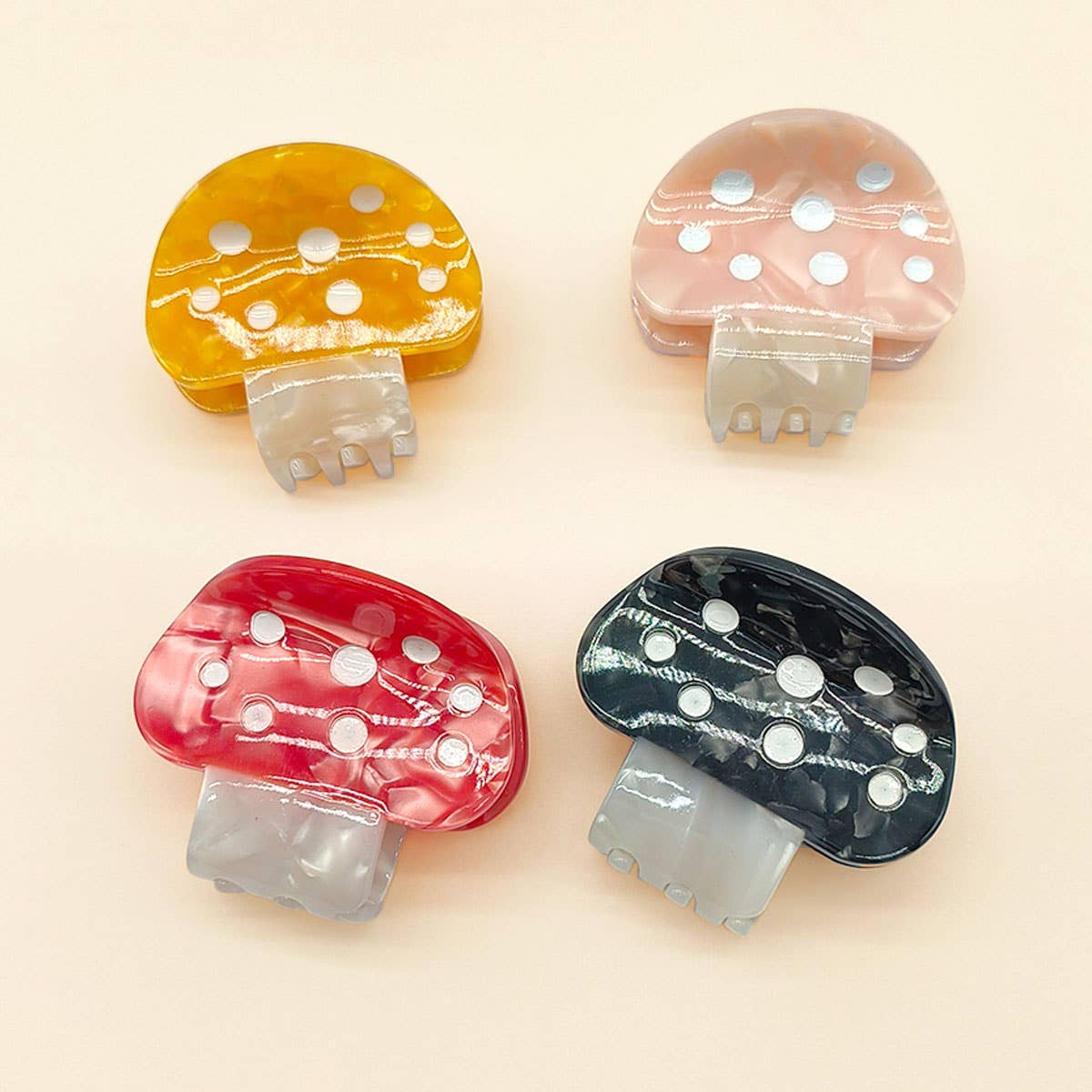 Four mushroom-shaped clips in different colors on a beige background
