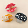 Three colorful hair clips on a beige background