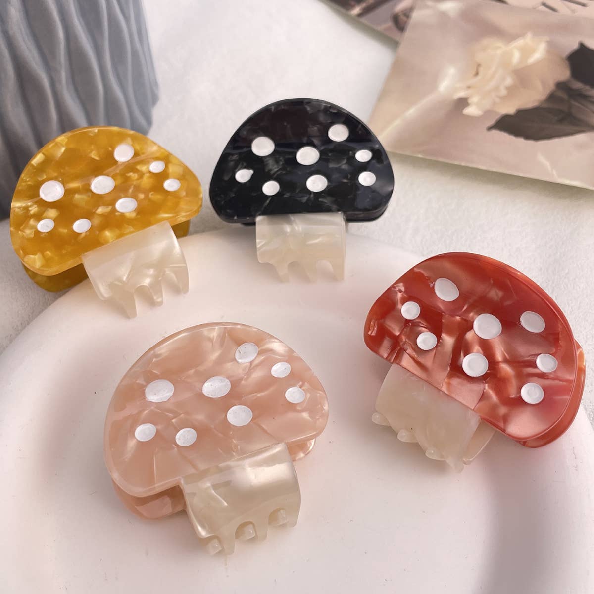 Four mushroom-shaped hair clips in different colors on a white surface.