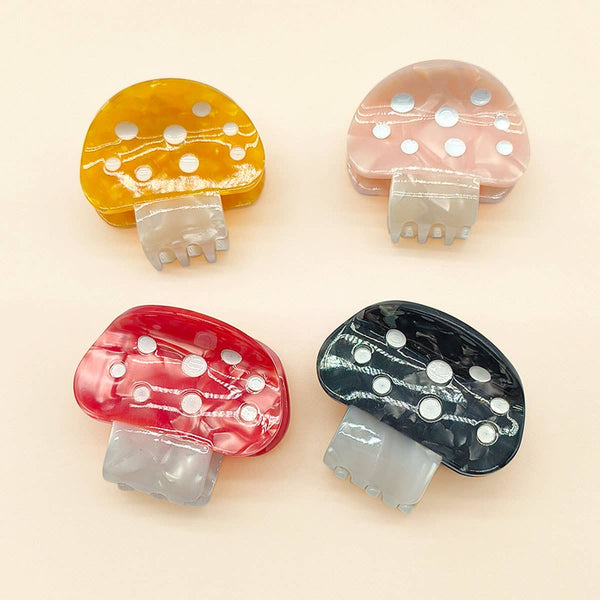 Four mushroom-shaped clips in different colors on a beige background