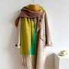 Beige coat with a colorful scarf draped over it on a white background