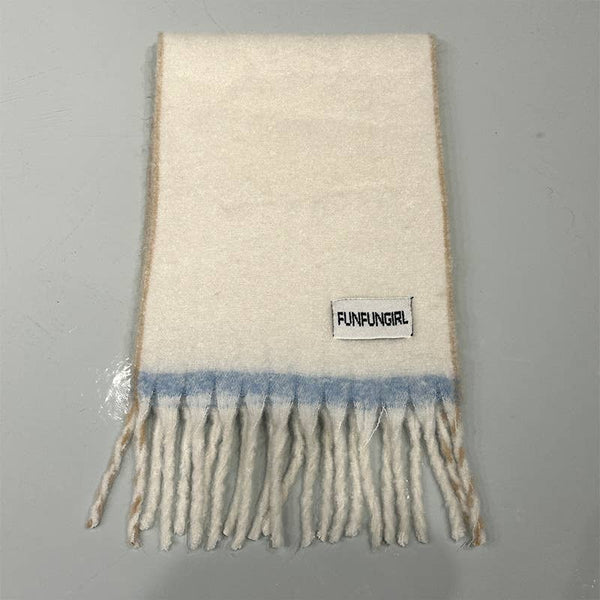 An off-white wool scarf with a light blue horizontal stripe and fringe, featuring a 'FUNFUNGRL' brand label, laid flat on a gray background.