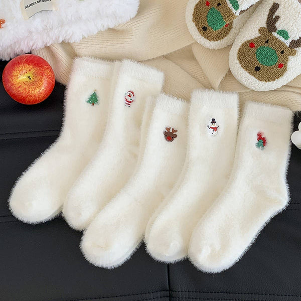 Set of white socks with Christmas-themed designs on a black surface.