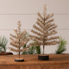 Two gold metallic trees on wooden stands with a neutral background