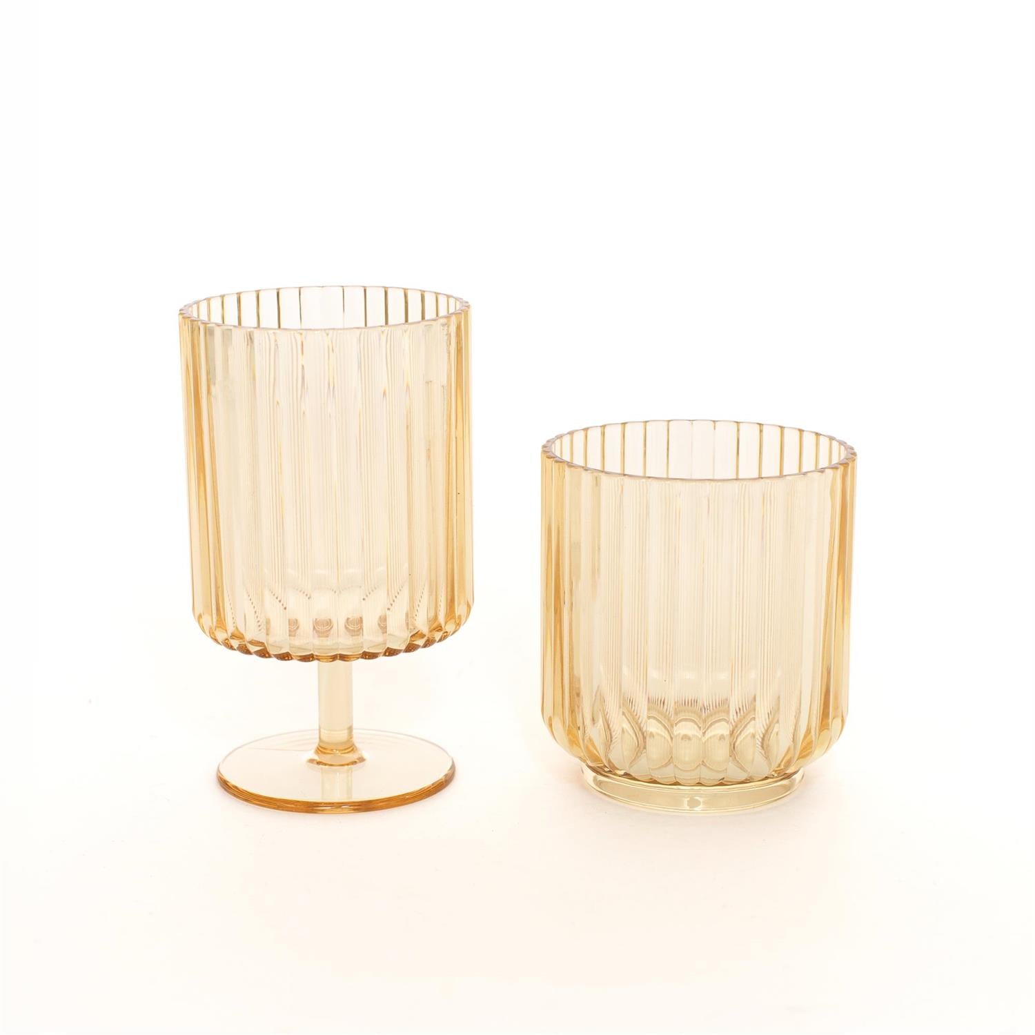 Two amber-colored ribbed glass tumblers, one with a stem and base and one shorter tumbler, on a clean white background.