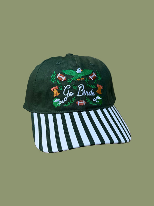 Green cap with embroidered design and striped visor on a green background