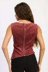 Woman wearing a maroon sleeveless top with a zipper on a white background