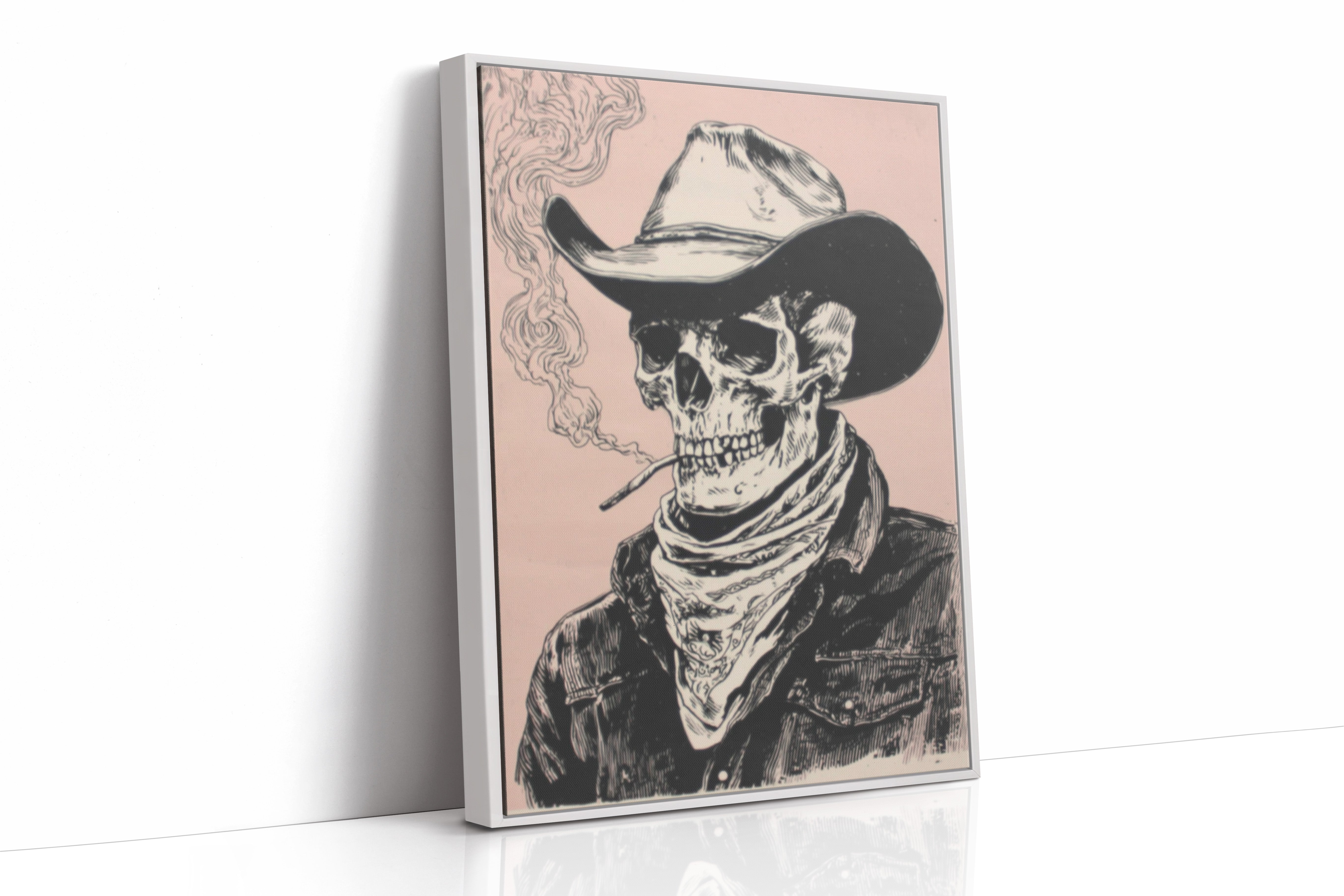 A framed vertical canvas print featuring a black and white sketch of a cowboy skeleton wearing a hat and bandana, smoking a cigarette against a dusty pink background. The canvas is shown standing at an angle on a white reflective surface.