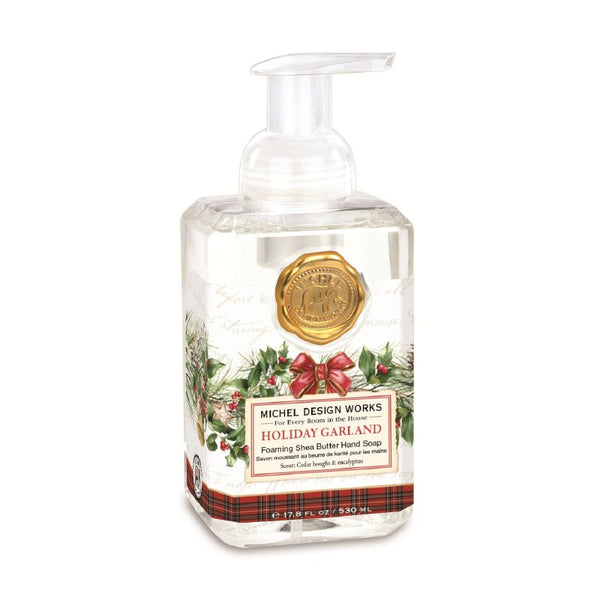 Michel Design Works Holiday Garland foaming shea butter hand soap in a clear rectangular pump bottle with a gold wax seal and festive holly label.