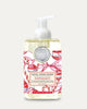 Michel Design Works Peppermint Foaming Shea Butter Hand Soap in a clear bottle with a white pump dispenser, decorated with red and white candy cane illustrations on a light beige background.
