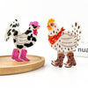 Two decorative chicken claw clips with western boots and accessories, displayed on a light wood tray against a white background.