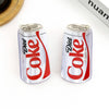 Two Diet Coke cans clips on a white surface with a 'huann' brand name visible.