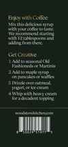 Back cover of a Woodstove Kitchen recipe book or booklet on a dark green background, with gold text reading 'Enjoy with Coffee' and 'Get Creative,' a website URL, and a barcode at the bottom.