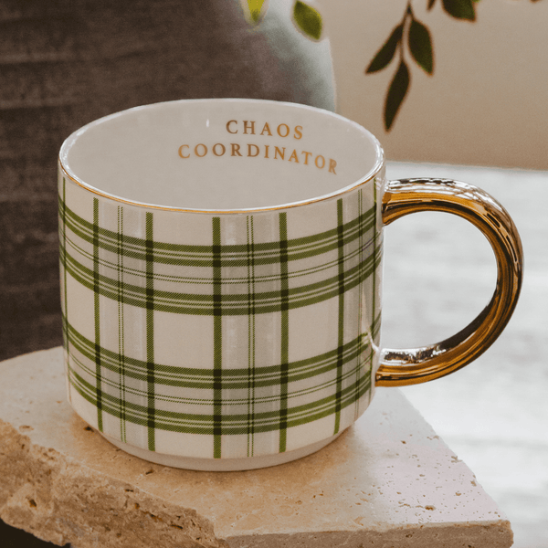 Mug with plaid design and 'Chaos Coordinator' text on a stone surface.