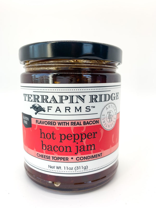 A jar of Terrapin Ridge Farms Hot Pepper Bacon Jam with a label that indicates it is flavored with real bacon and is gluten-free, dairy-free, free of saturated fat and cholesterol.
